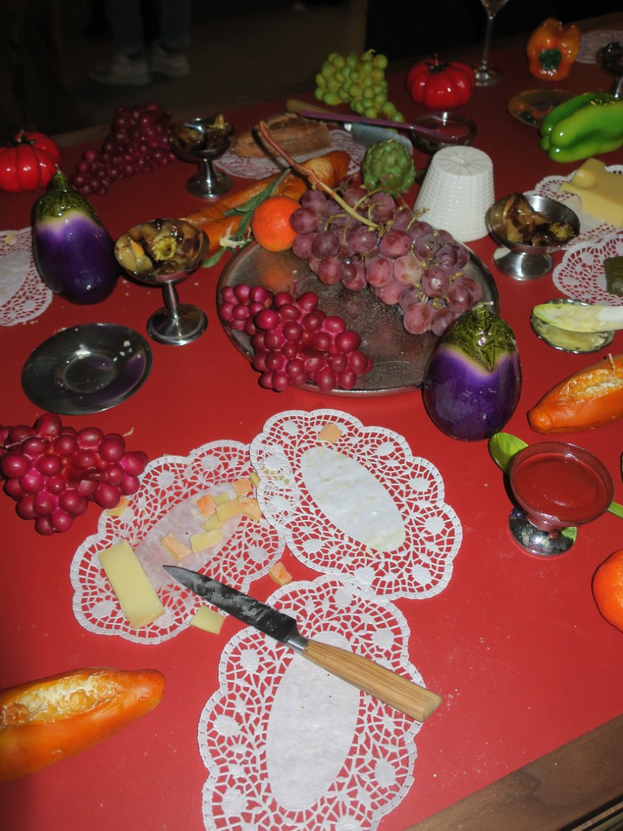 A long table set with LUCE figure candles arranged like a still life