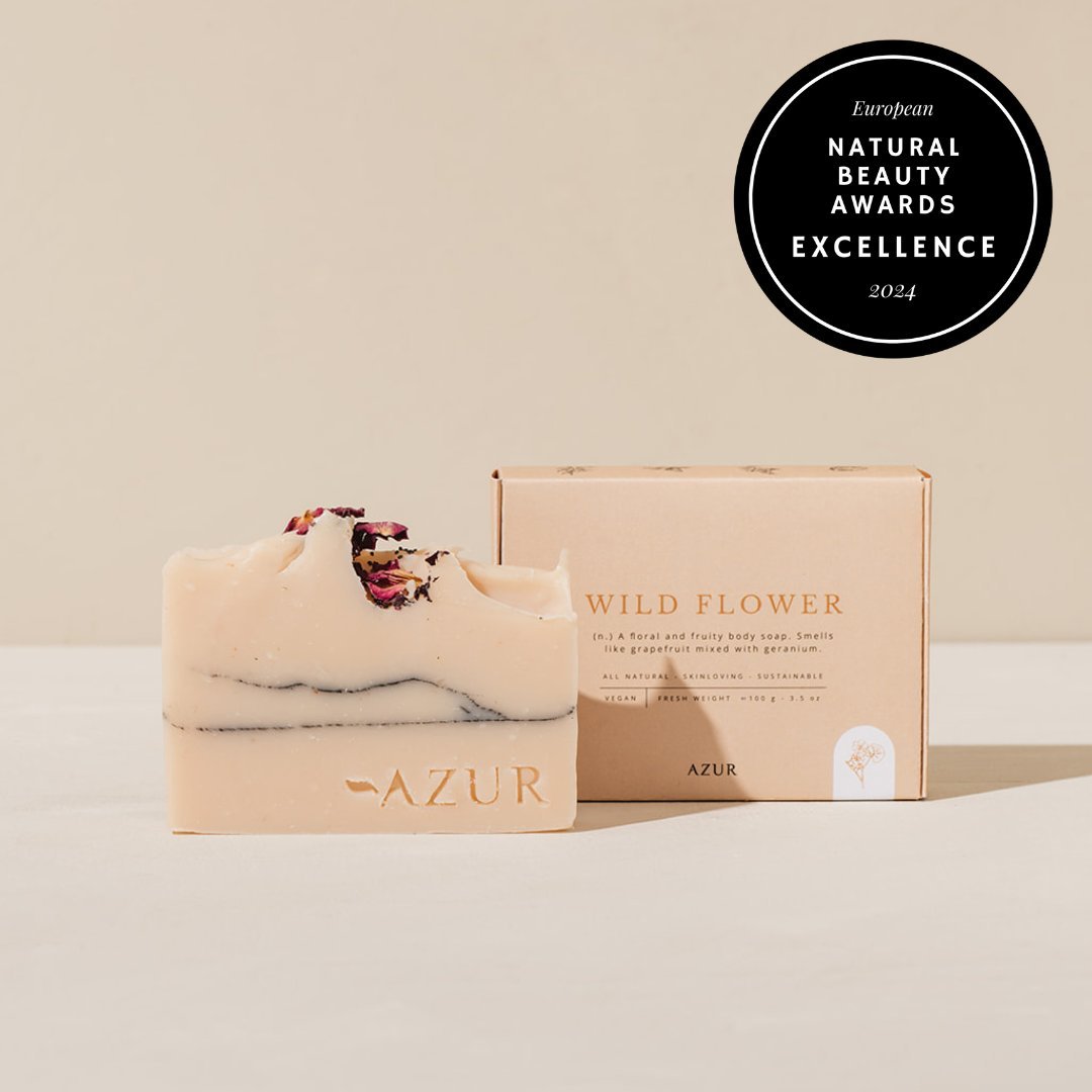 The Wild Flower bar beside its carton, dried rose petals set into its uneven top, the awards badge in the corner.