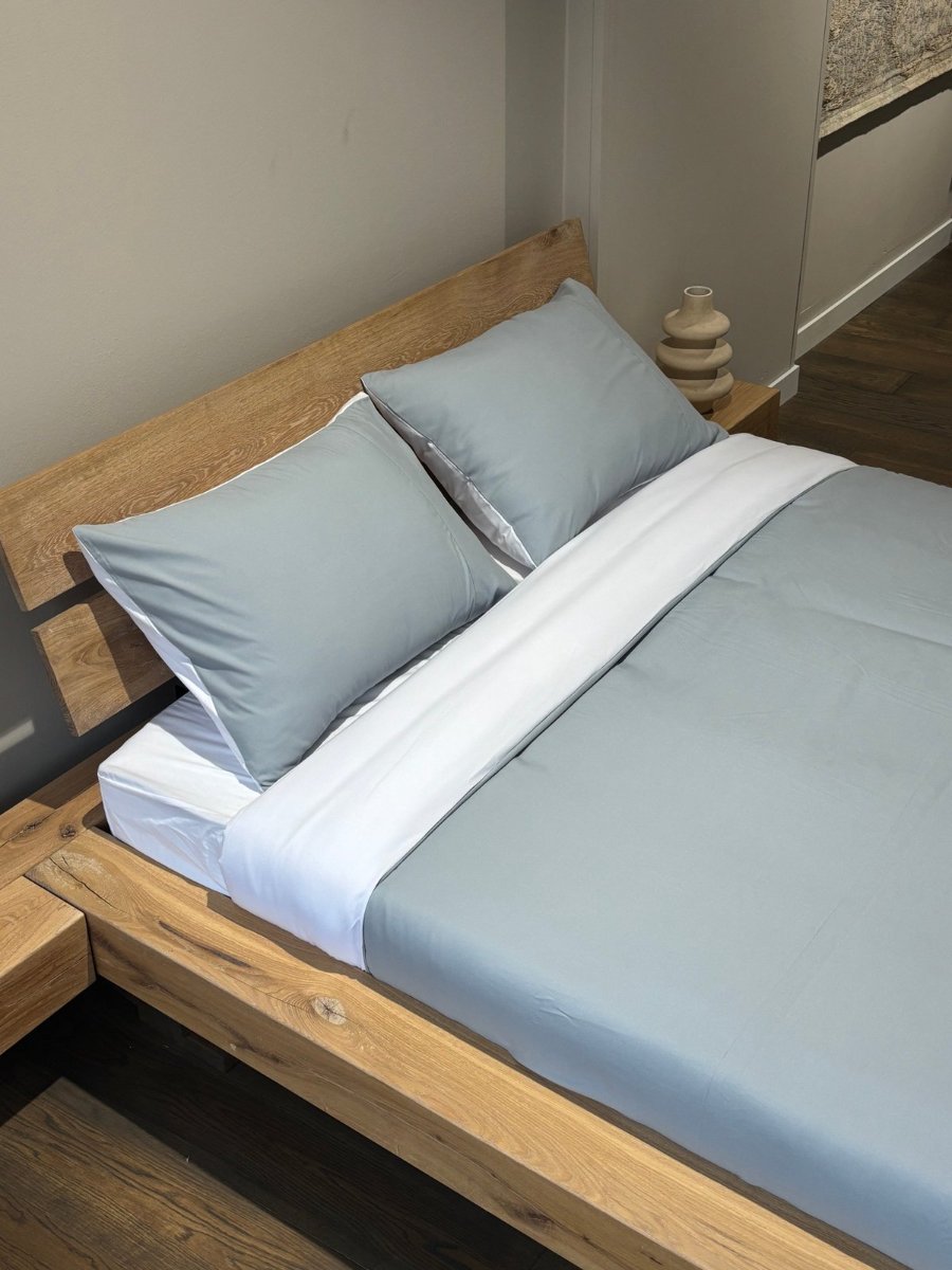 A fitted sheet on a wooden bed frame.