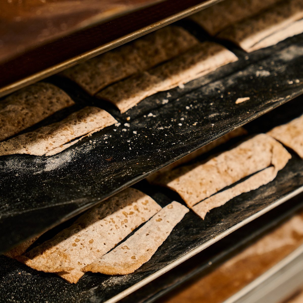 Knäckebröd auf bemehlten schwarzen Blechen im Bäckerwagen.