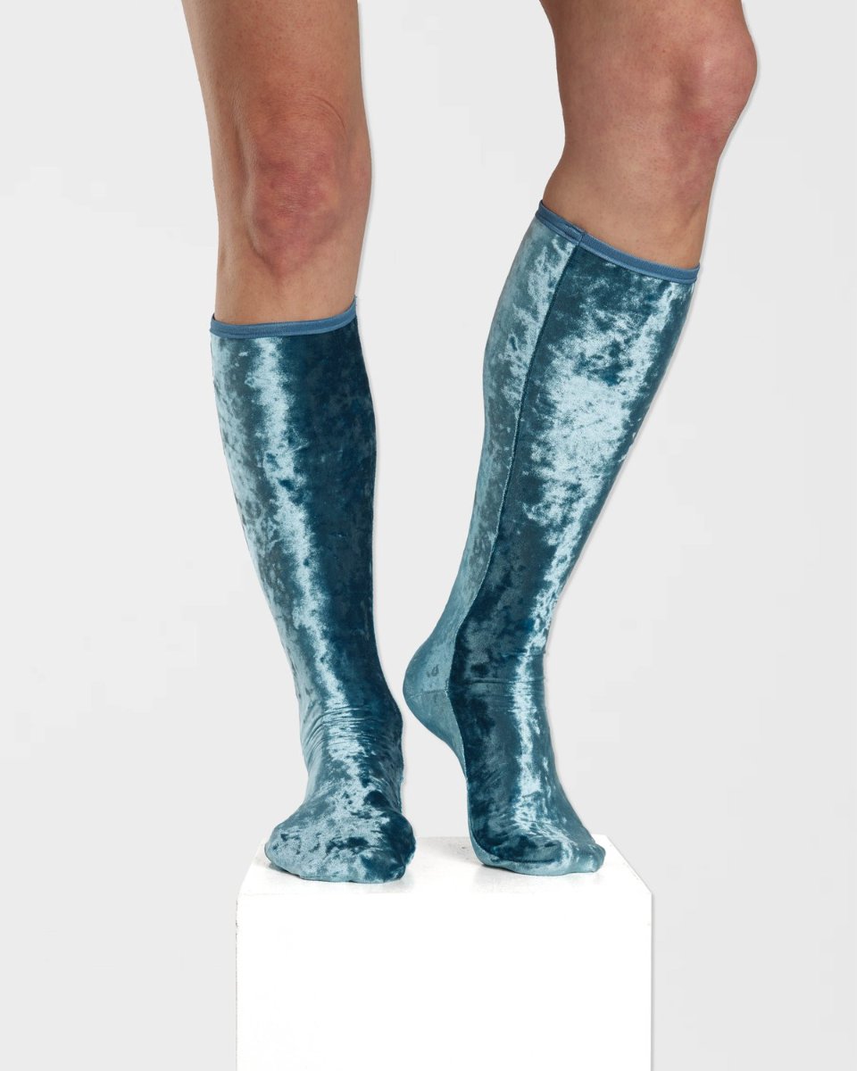 Crushed velvet knee socks in petrol, on a plinth