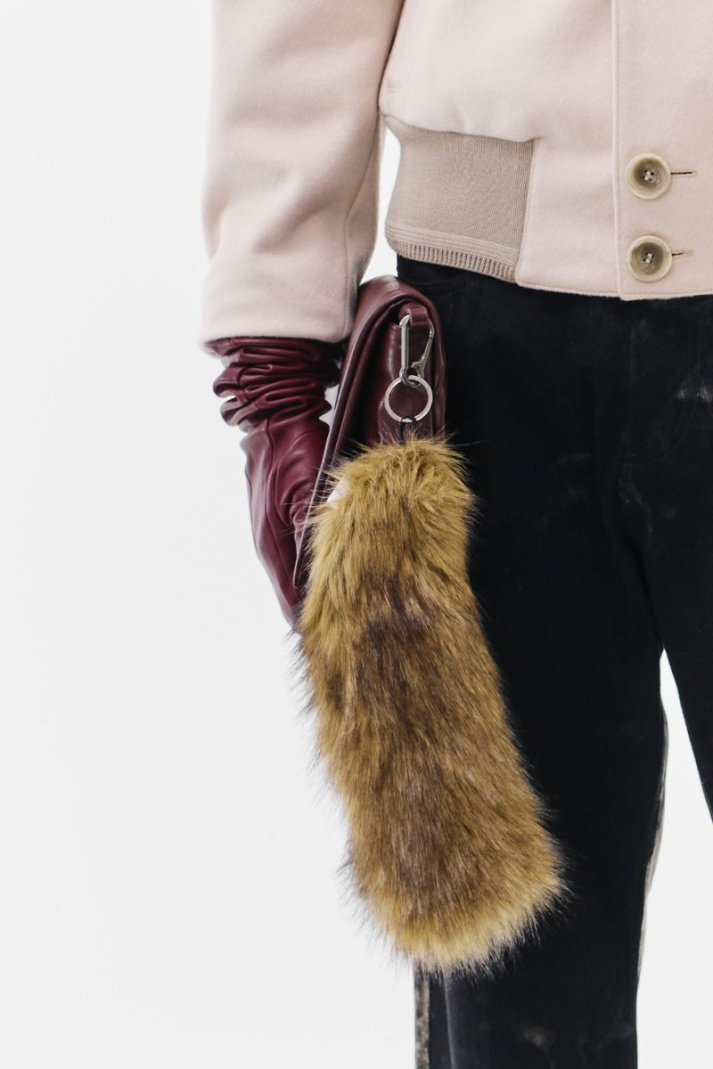 The tail on its carabiner, clipped to a burgundy leather pouch.