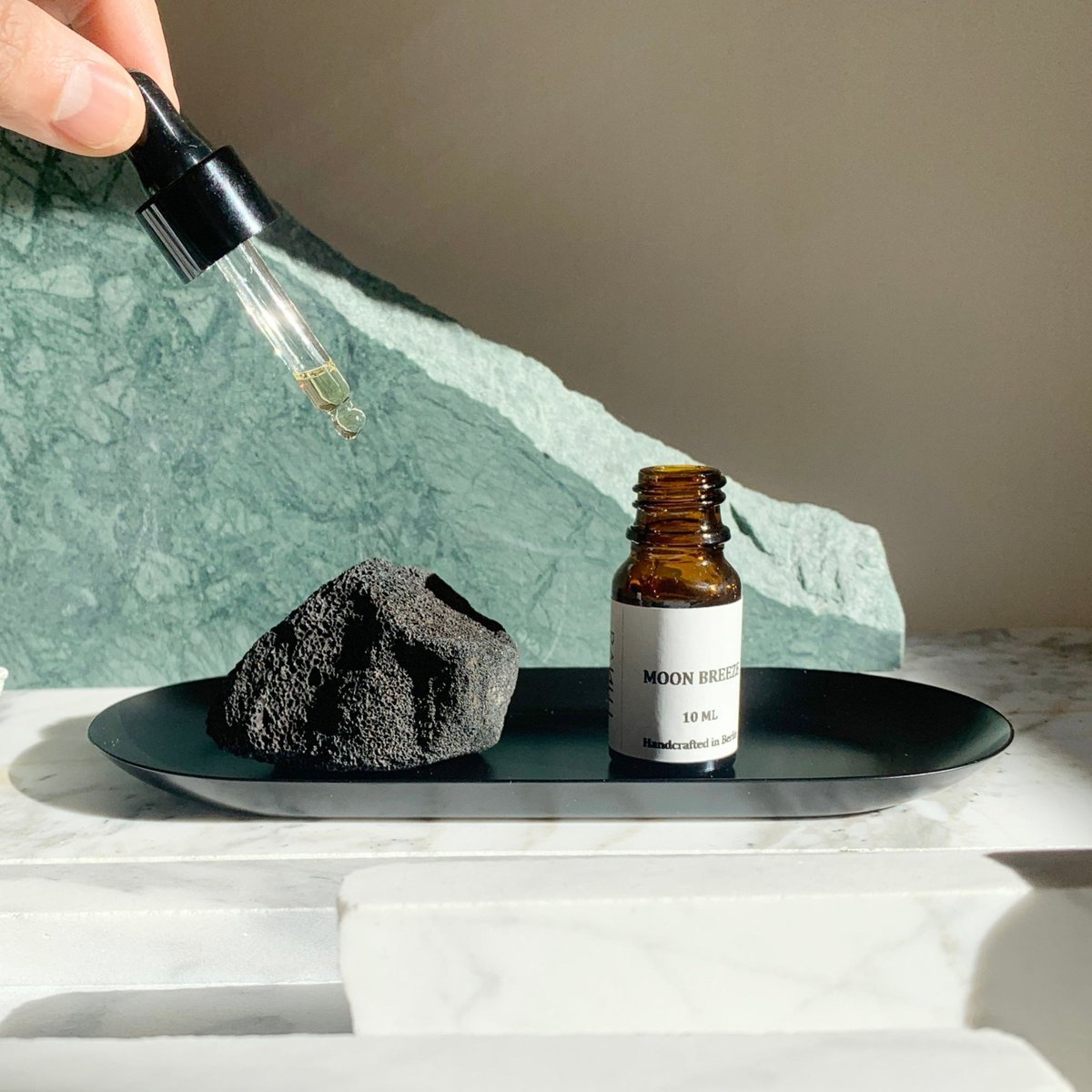 A pipette held over the tray, the lava stone and Moon Breeze side by side