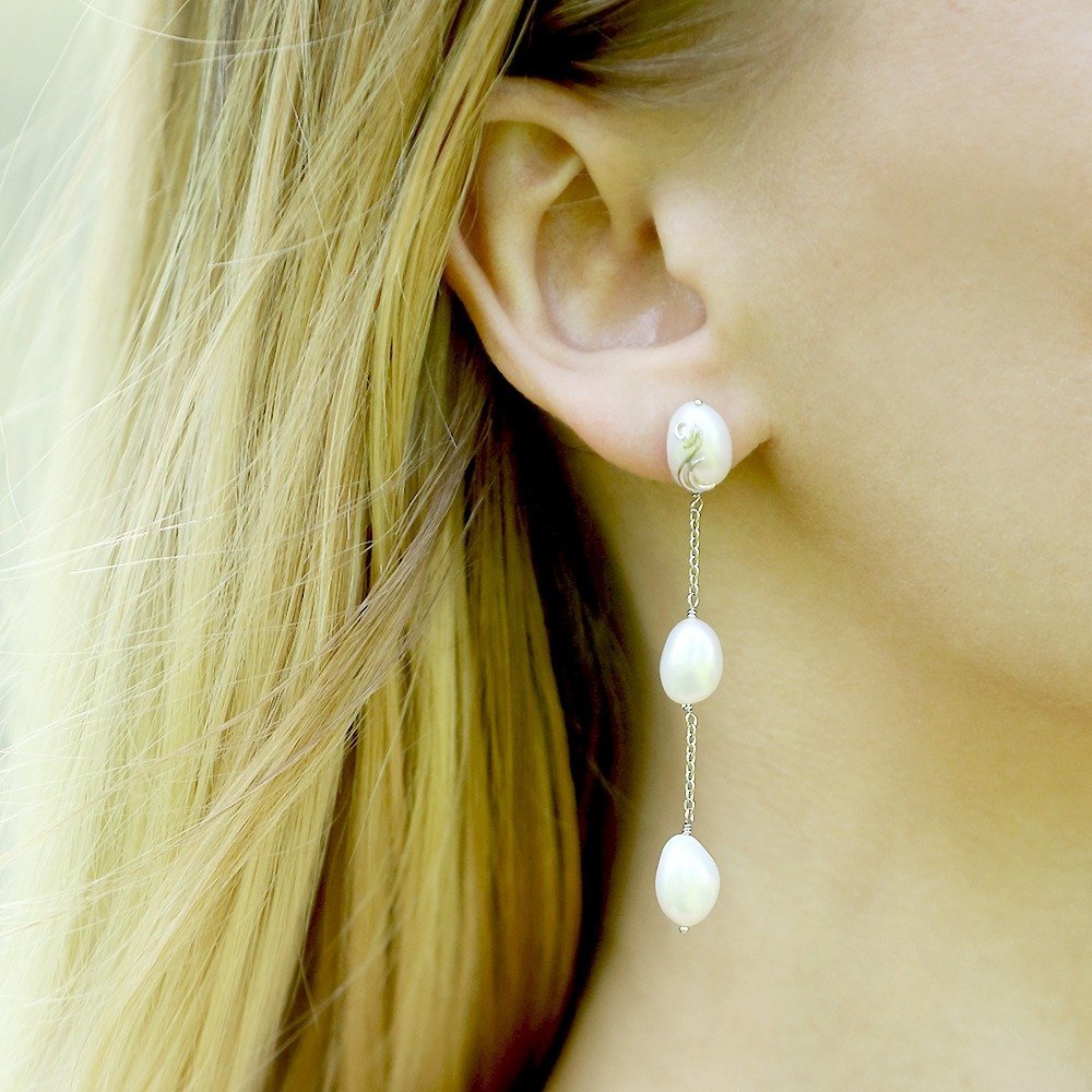 The Serafina earrings worn, with one pearl at the ear and two on fine chains below.
