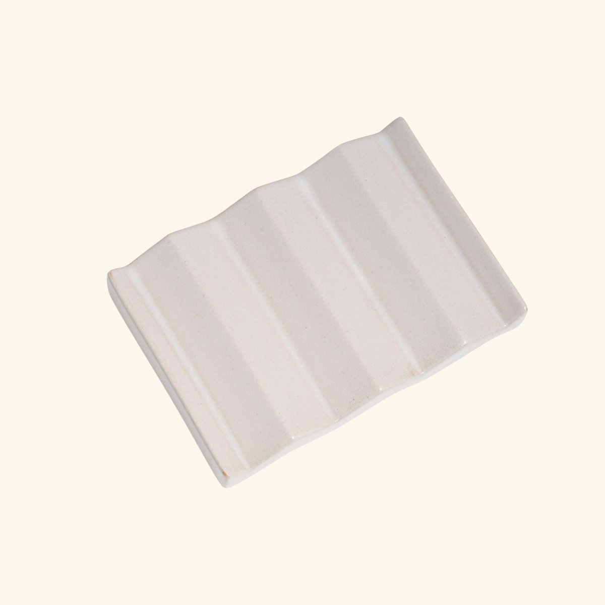 The ROCKY M. soap dish, its zigzag profile holding the bar above the water