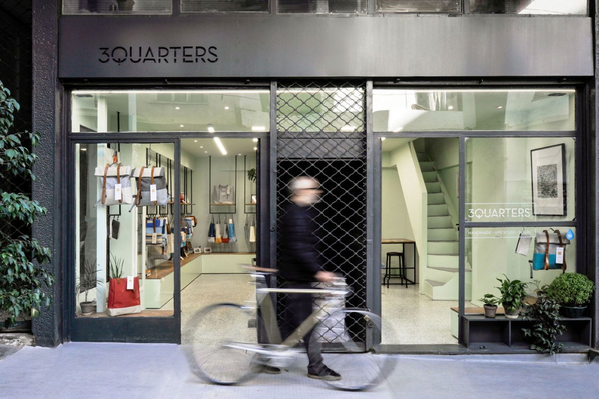The 3QUARTERS shop front in Psyri, a cyclist passing the window